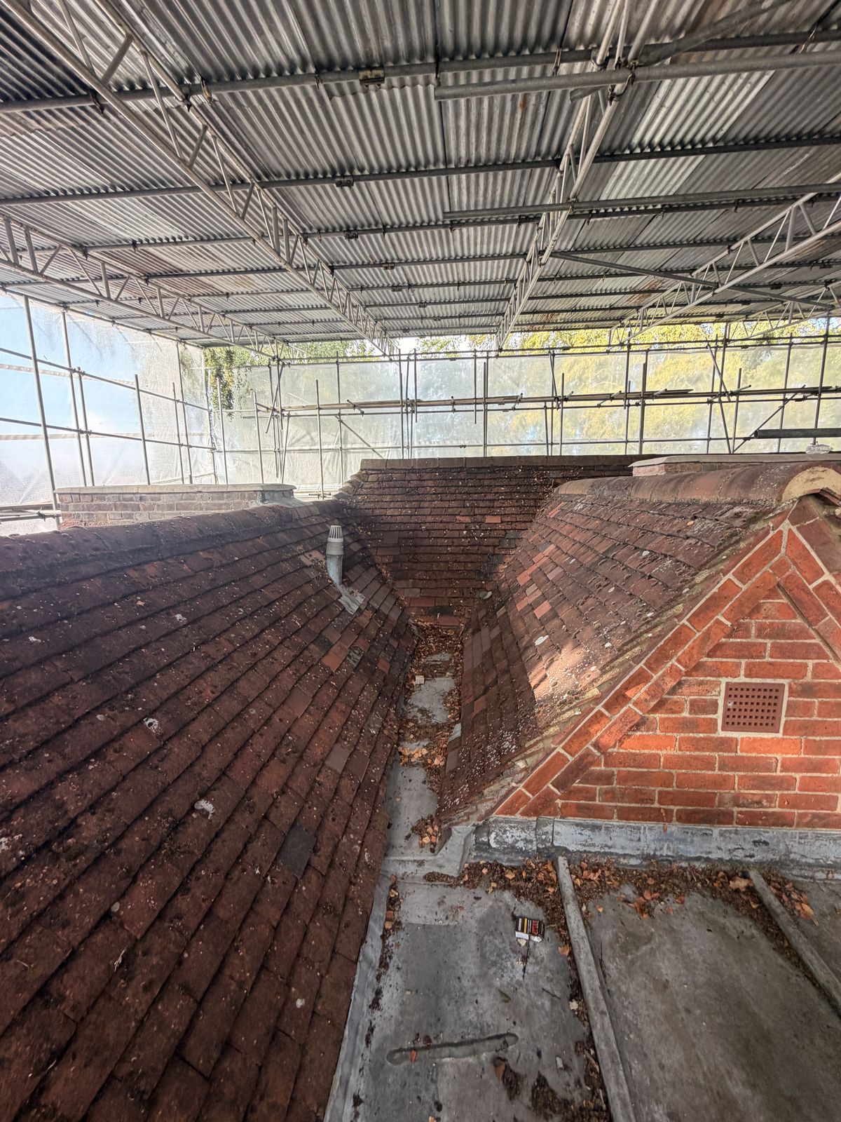 Valley between two pitched roof slopes with flat area alongside
