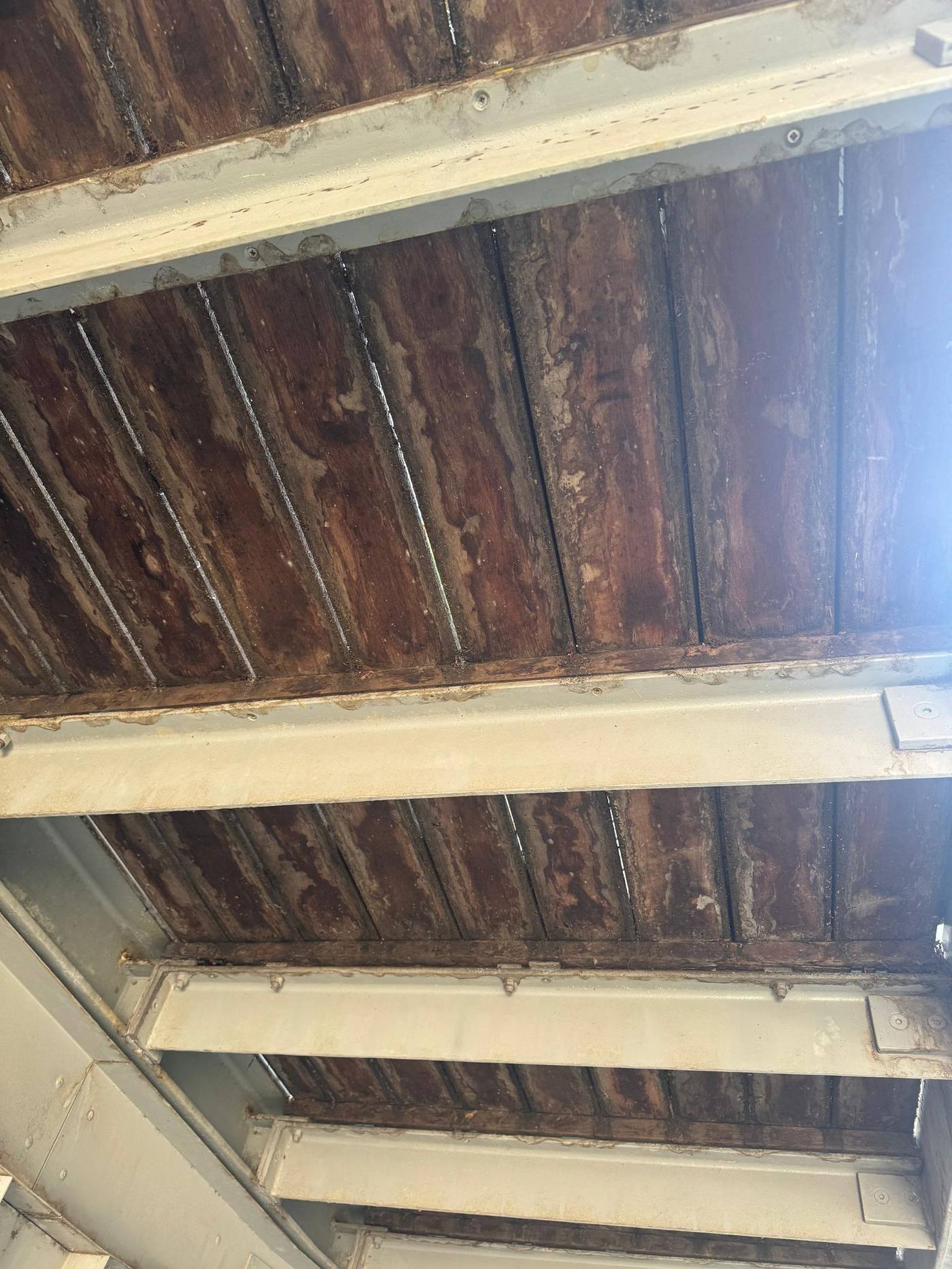 Underside of original decking showing water staining, rot and corrosion at fixings