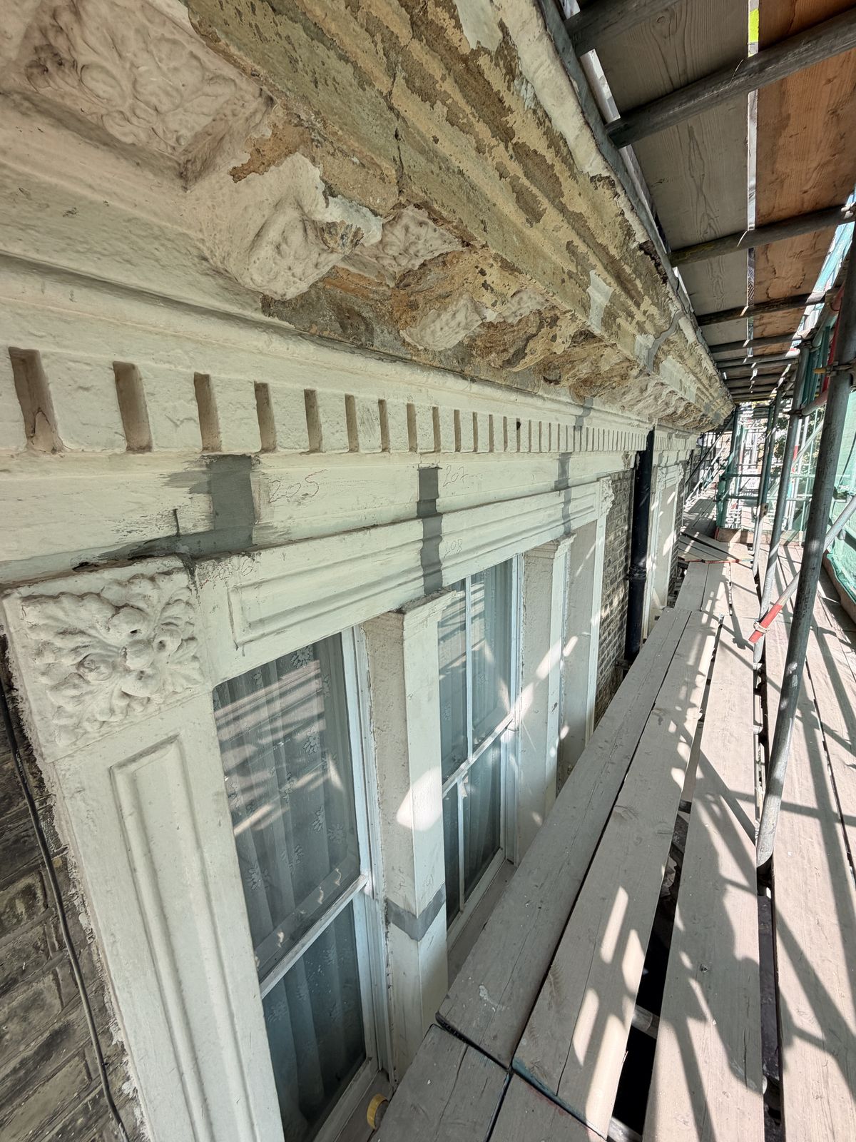 Dentil course and cornice with numbered survey marks